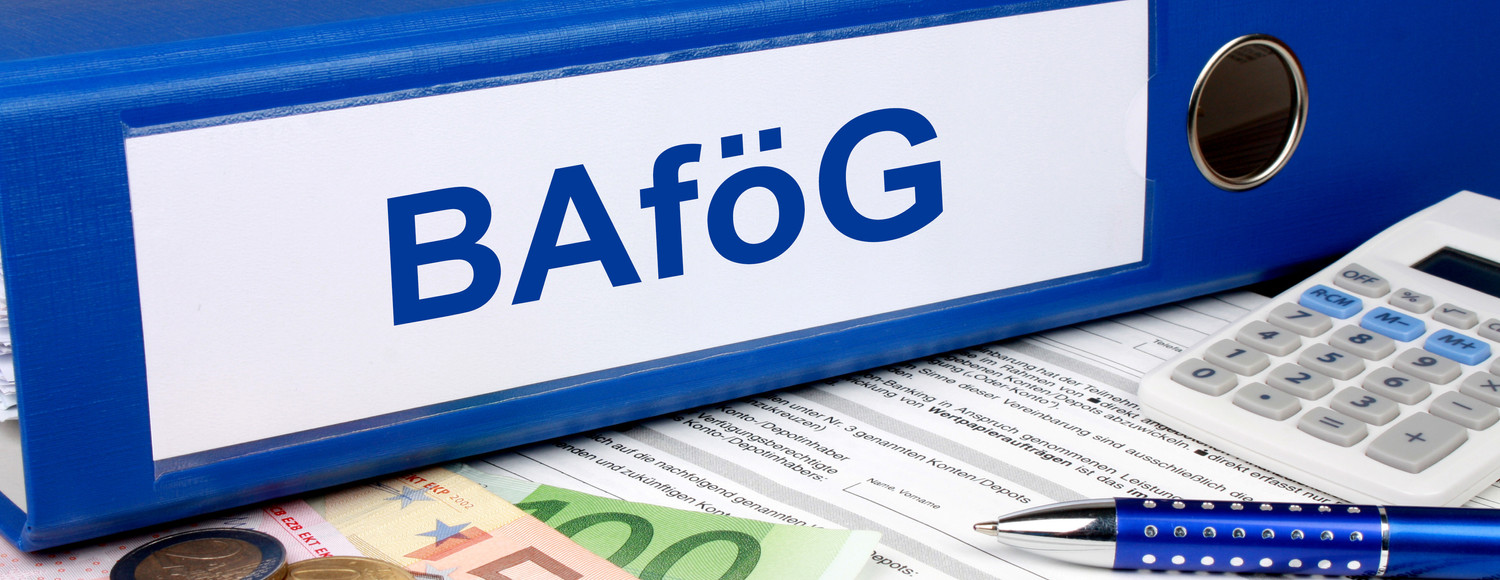 KI generiert: Das Bild zeigt einen blauen Ordner mit der Beschriftung "BAföG", umgeben von einem Taschenrechner, Euro-Banknoten, Münzen und einem Kugelschreiber. Es vermittelt den Eindruck von finanziellen Unterlagen oder Anträgen im Zusammenhang mit der Studienfinanzierung in Deutschland.