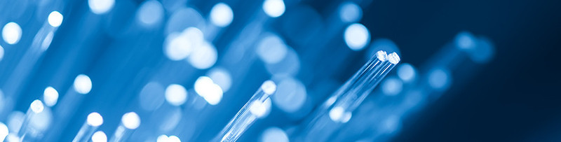 Leuchtende Glasfaserkabel vor einem blauen Hintergrund. 