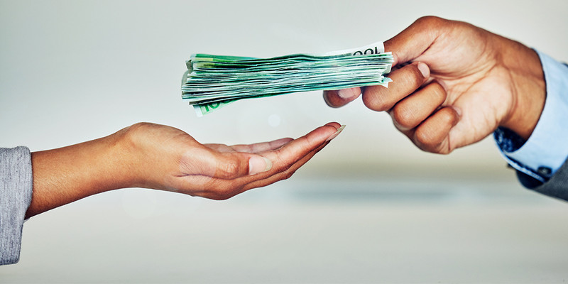 KI generiert: Das Bild zeigt eine Person, die einem anderen Geld in Form von Euro-Scheinen übergibt. Die Hände sind der zentrale Fokus des Bildes.