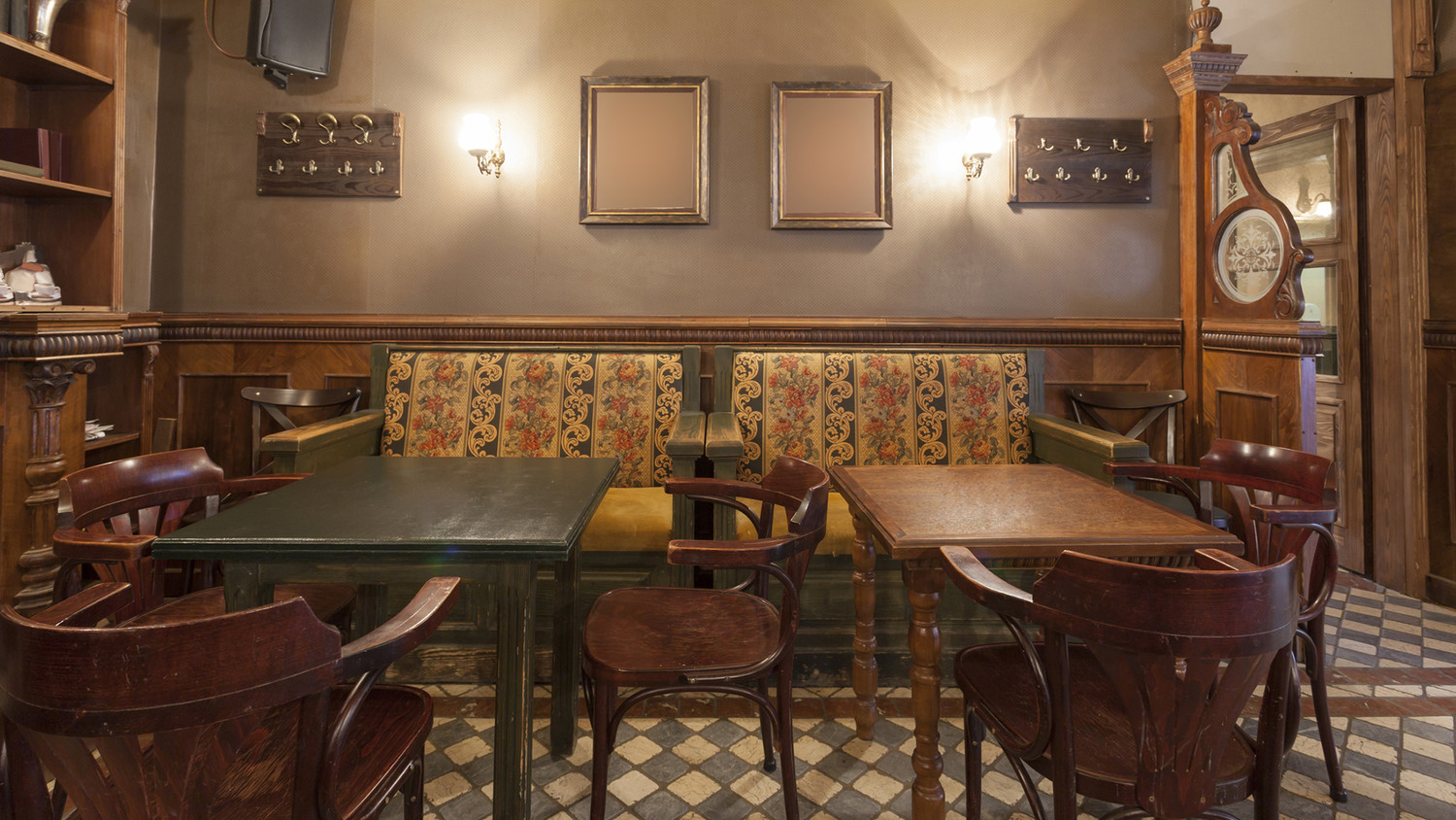 KI generiert: Das Bild zeigt den Innenraum eines gemütlichen Cafés oder Restaurants mit Holzmöbeln, einer gepolsterten Bank und beleuchteten Wänden. Die Atmosphäre wirkt einladend und traditionell.